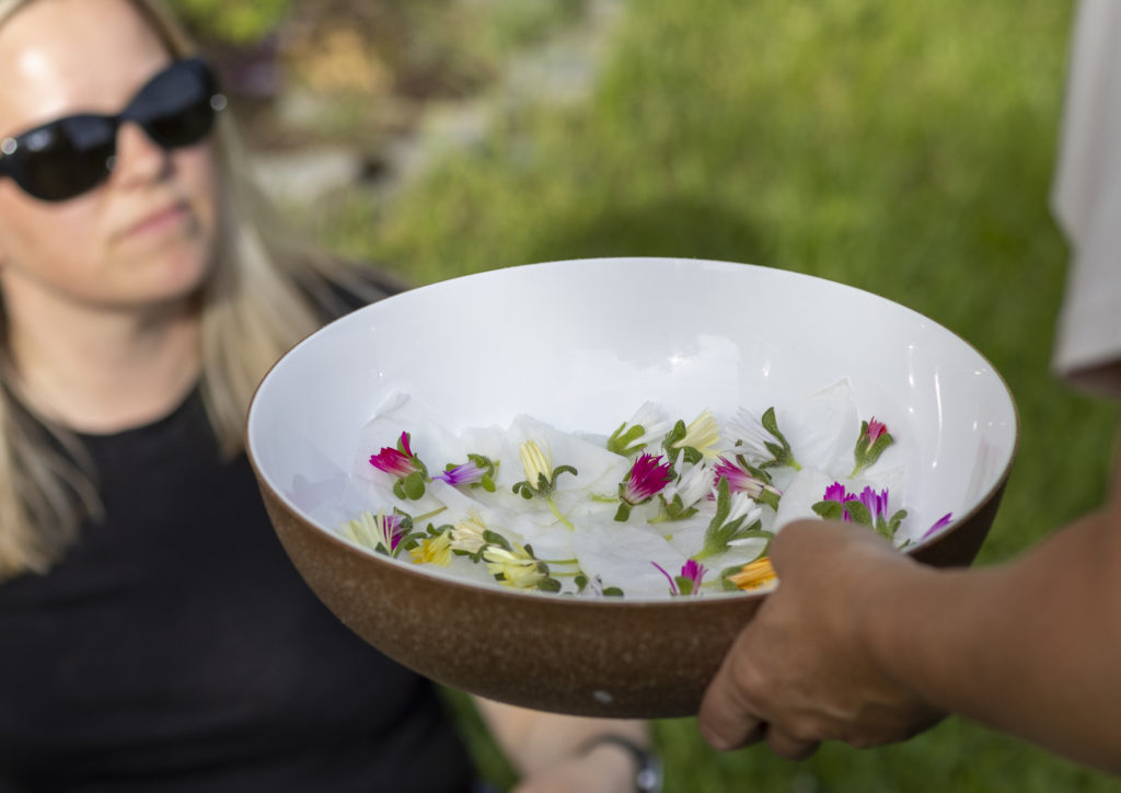 To kvinner ser på nyplukkede blomster på et fat. Foto: Augeblikk Studio